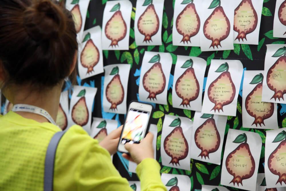 A woman at a Studio Health event taking a photo of a wellness wall.